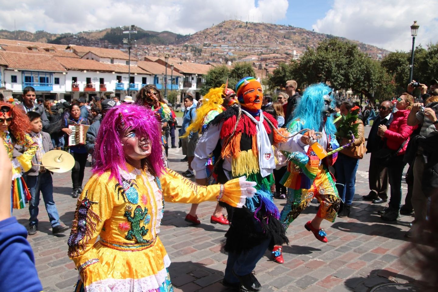 Zdjęcie przedstawia korowód kolorowo ubranych osób